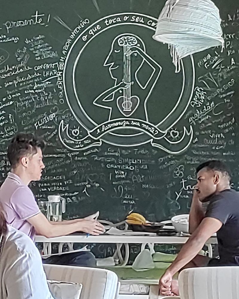 A varanda com a lousa da mandala, e duas pessoas em conversa na mesa