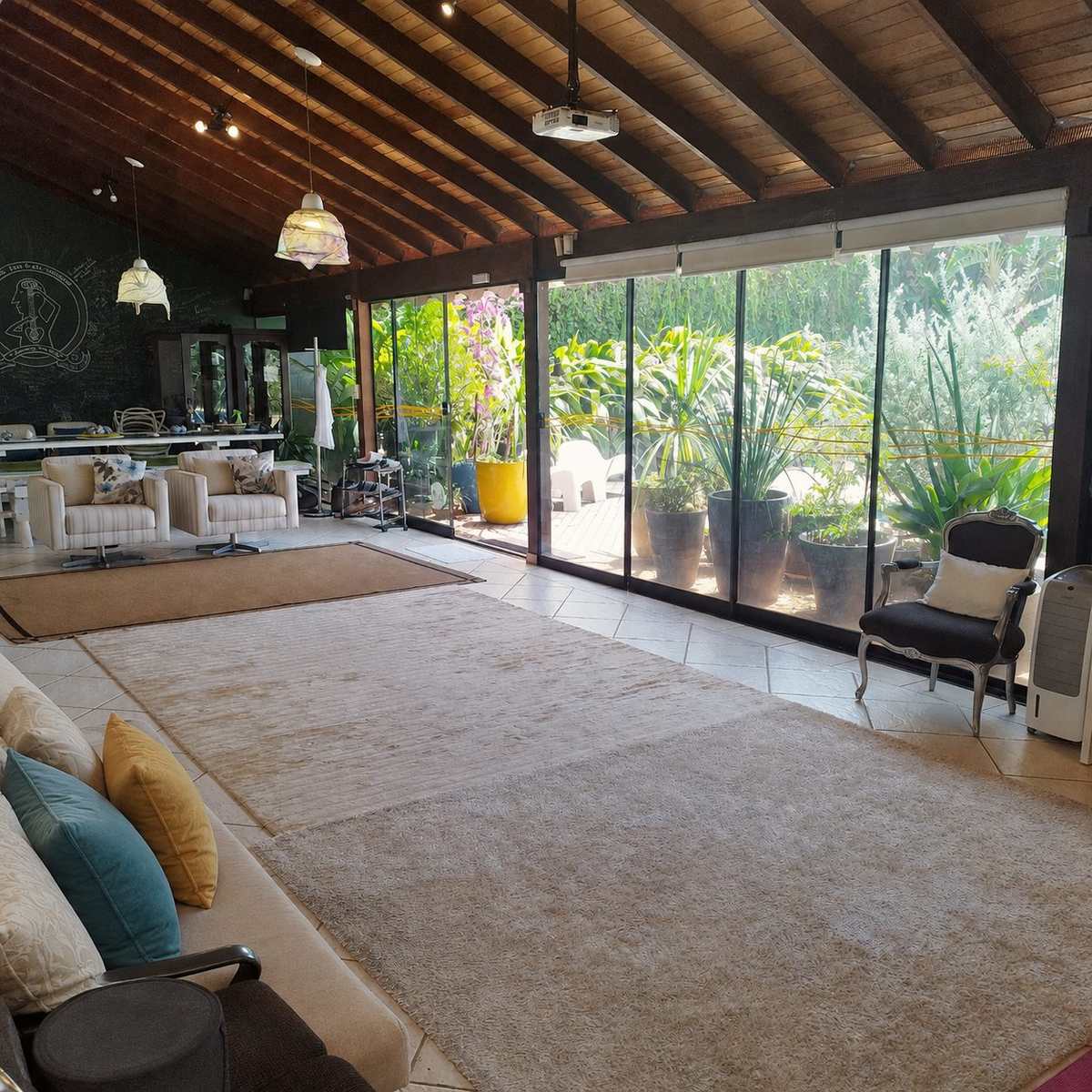 A sala principal da casa, com o jardim visto pelas paredes de vidro